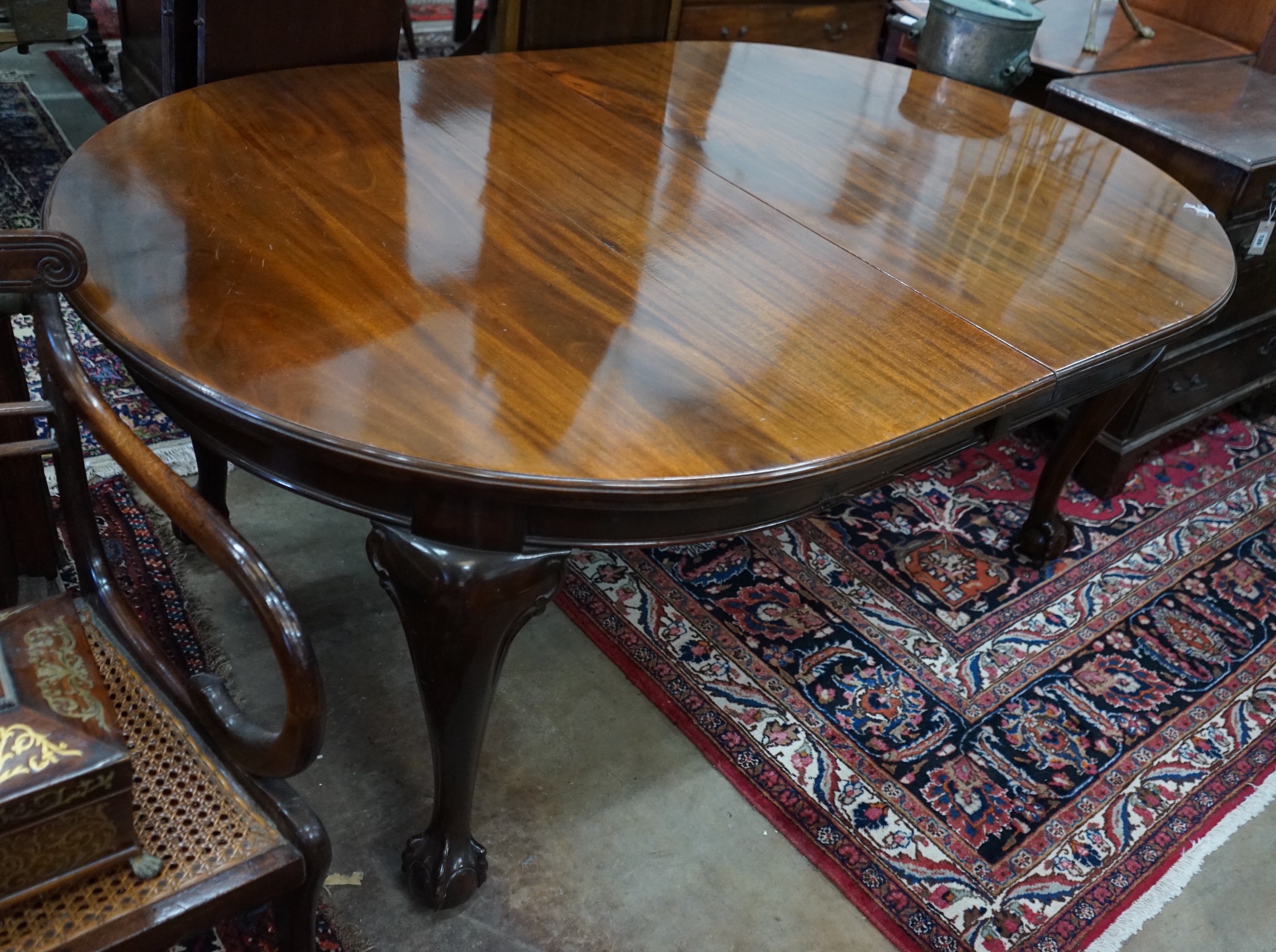 A 1920's mahogany extending dining table on ball and claw feet, with three spare leaves, 296cm extended, width 120cm, height 73cm